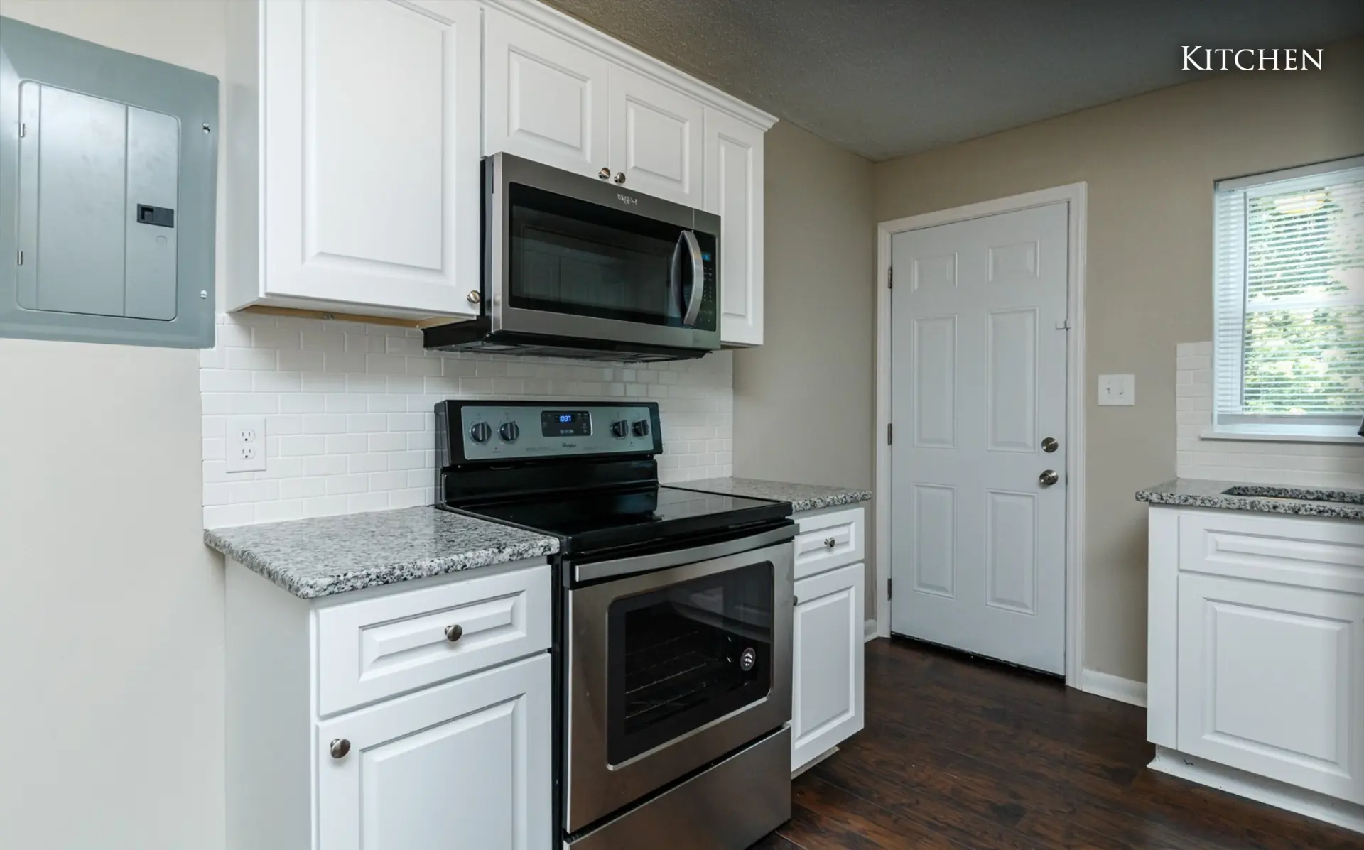 Unit A kitchen range, microwave and back door