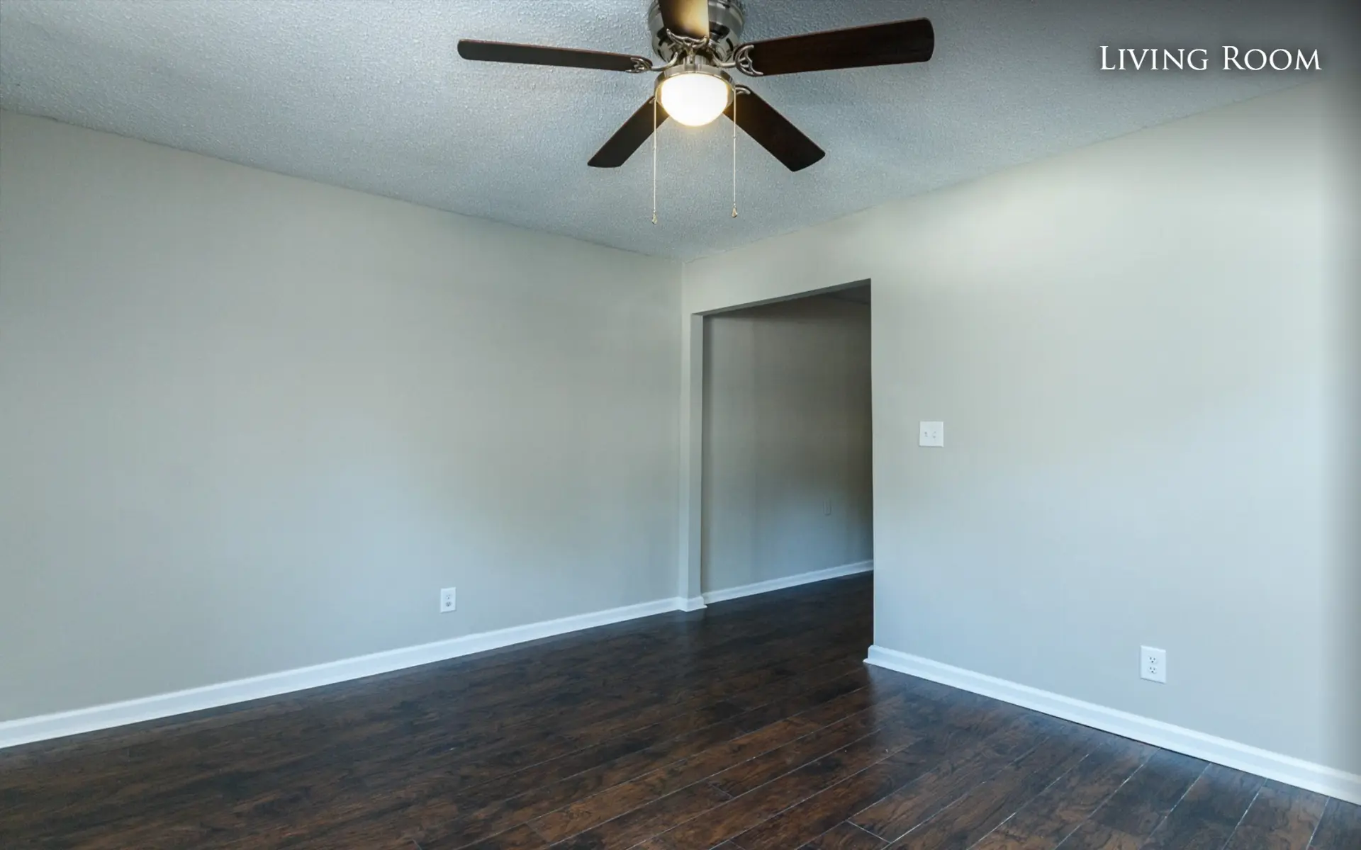 Unit B living room with ceiling fan and hallway